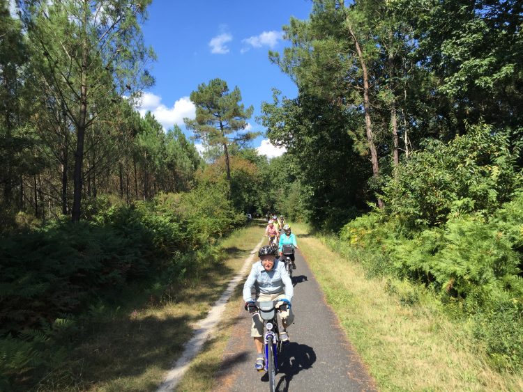 Cyclists on green cycling path in Medoc
