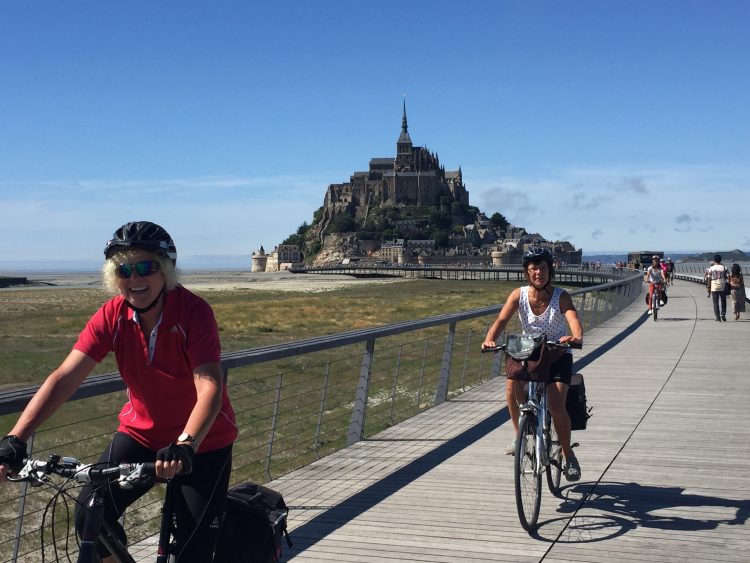 Cyclists on the Véloscénie with the Mont-Saint-Michel in the background