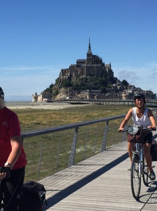Radfahrer mit dem Mont Saint-Michel im Hintergrund