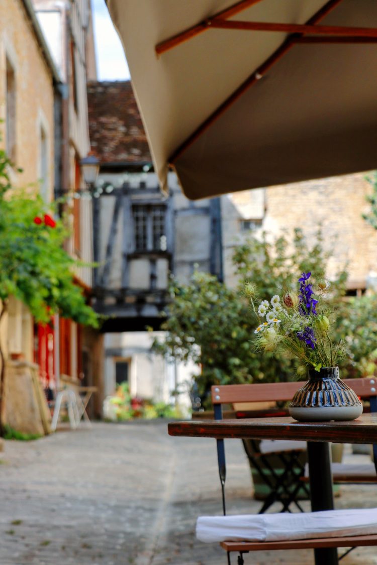 vue sur une terasse avec des fleurs sur la table à noyers